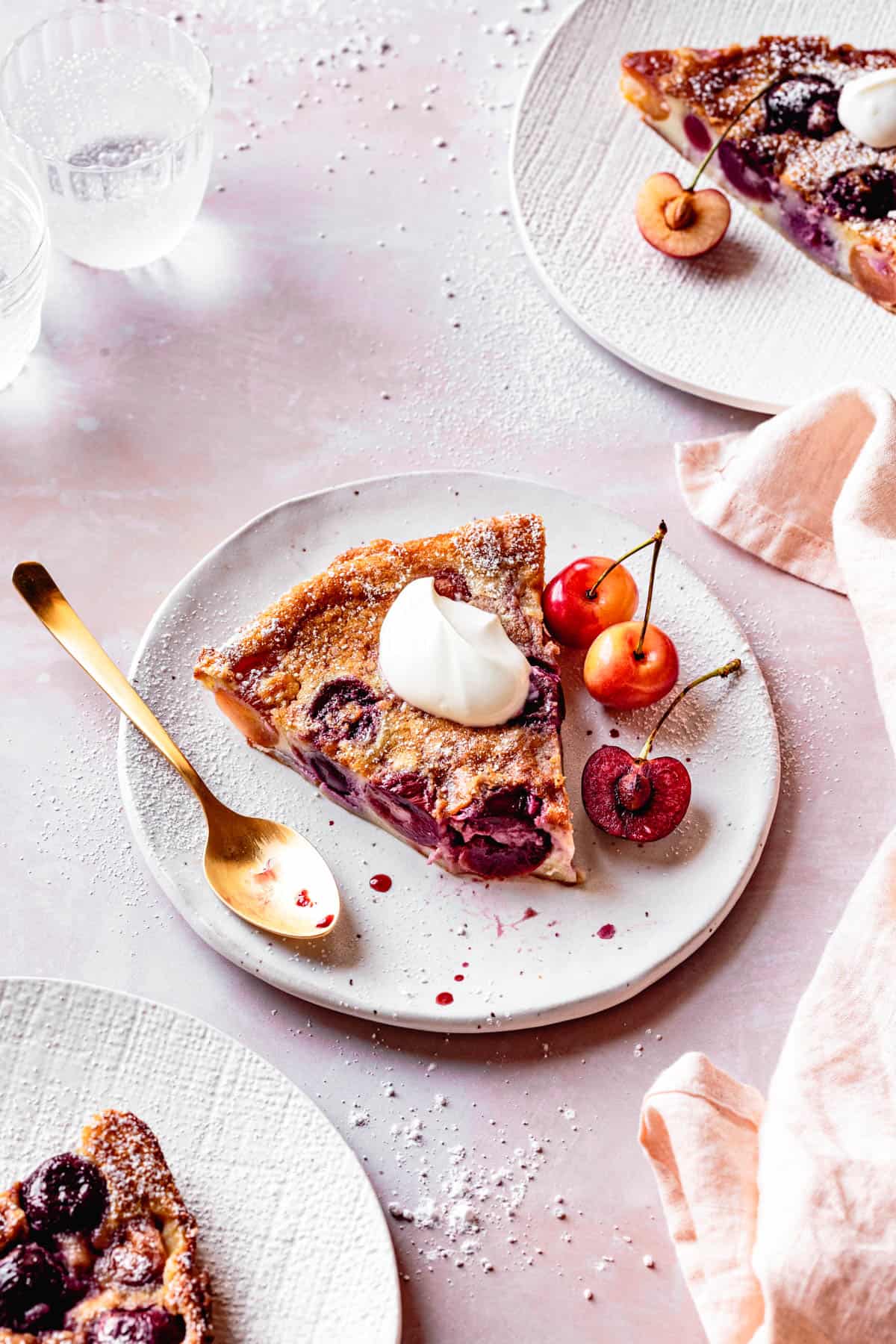 Gluten Free Cherry Clafoutis slice on a plate with creme fraiche