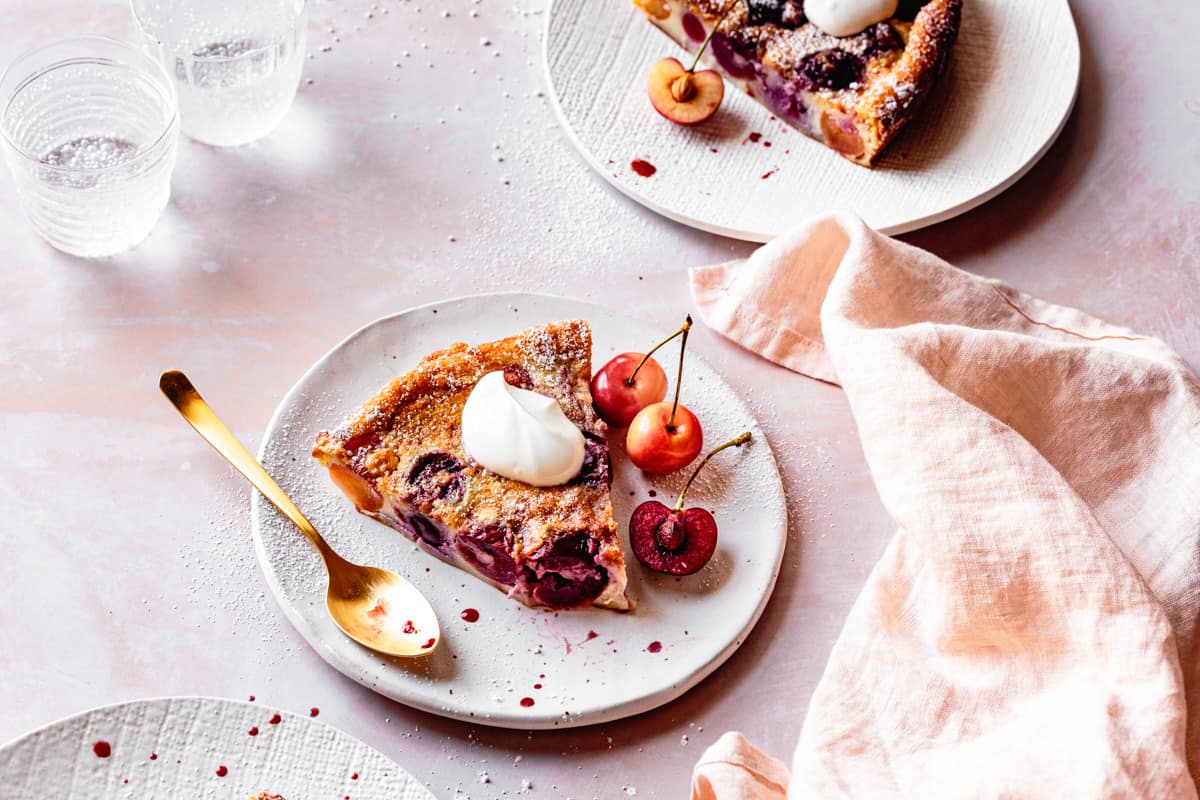 Gluten Free Cherry Clafoutis slices on plates with creme fraiche