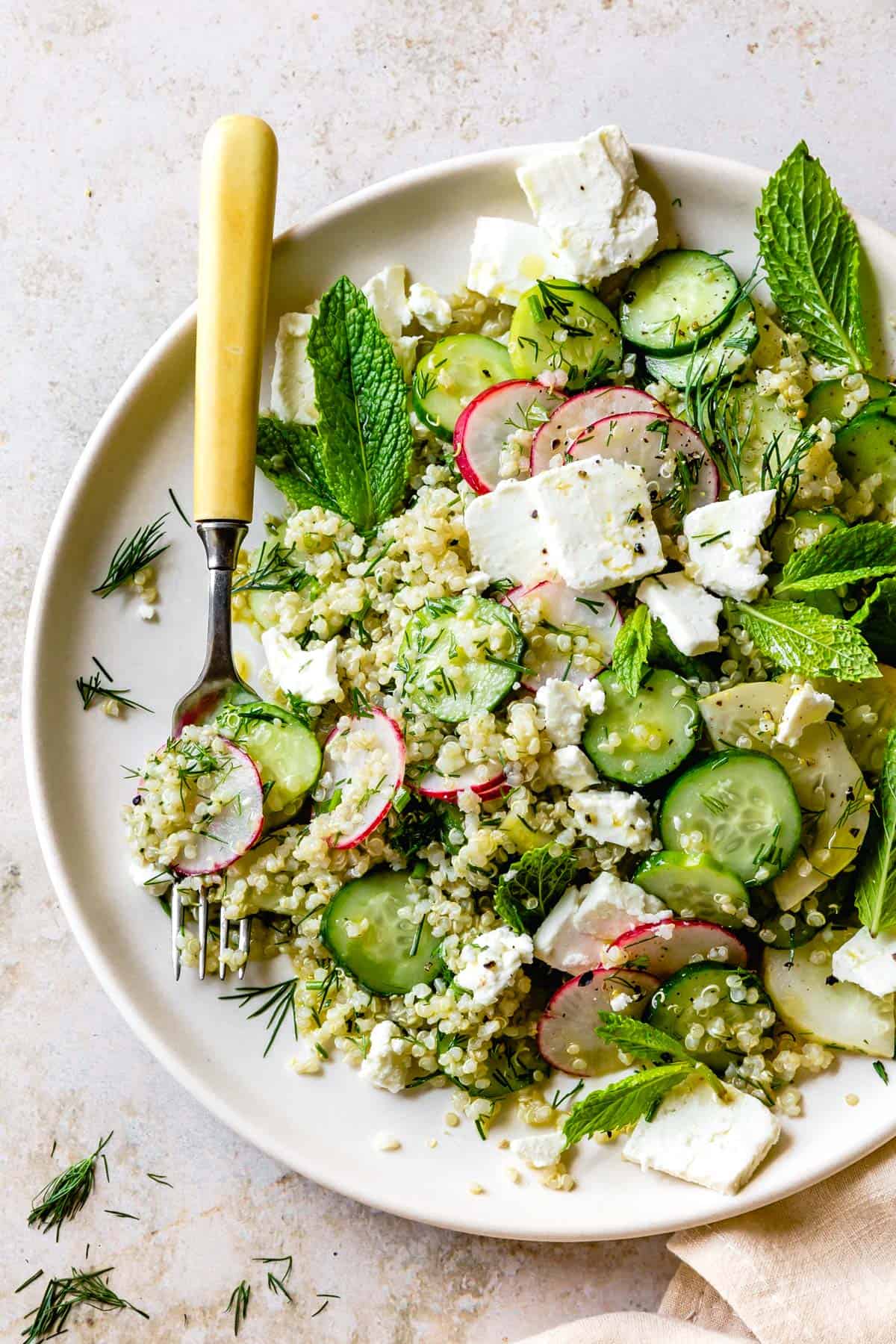 delicious Quinoa Cucumber Salad with Feta, Dill & Mint on a plate with fork 