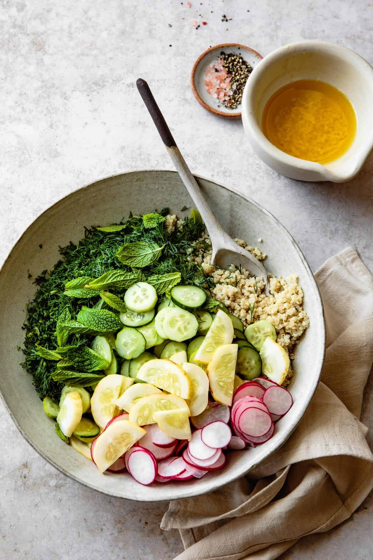 Combining ingredients for summer quinoa salad in a bowl