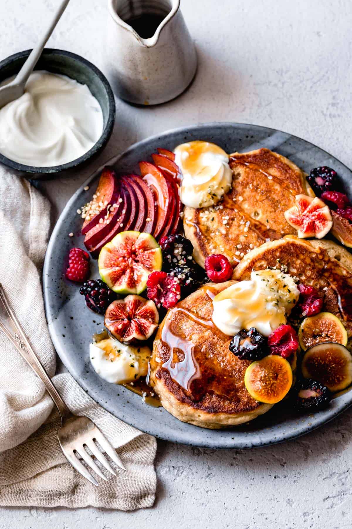 a pile of pancakes and fruit are ready to be devoured