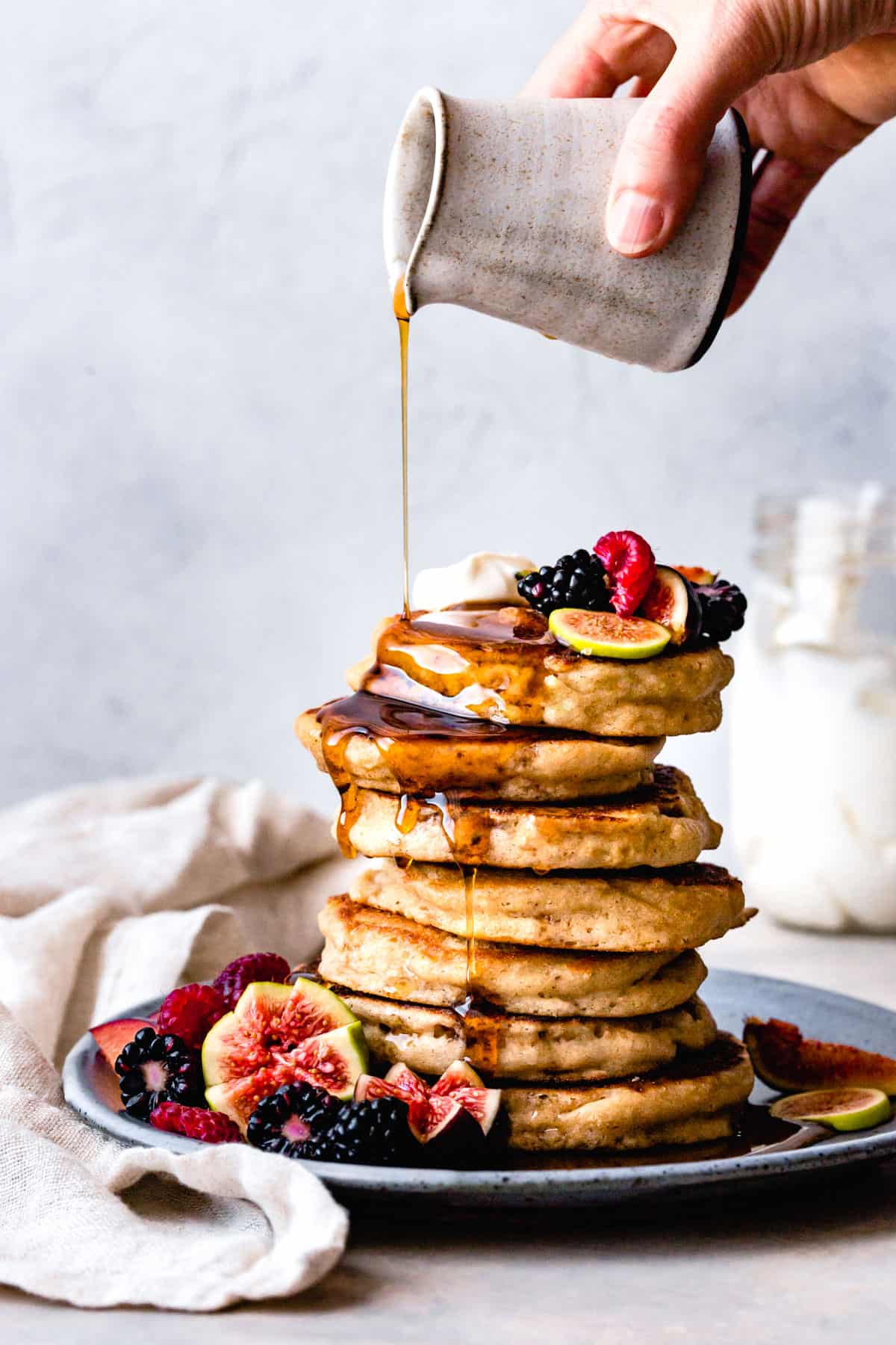 Pouring maple syrup on my best gluten-free pancakes (with dairy free, vegan, egg-free, sugar free options without xanthan gum)