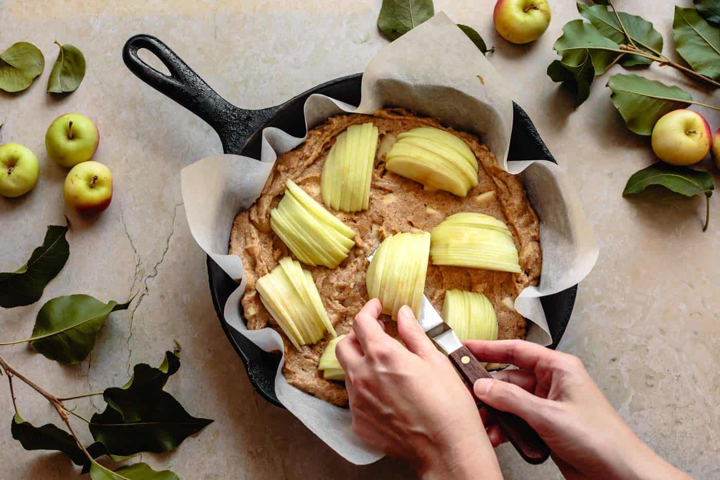 Placing apples on top of the gluten-free apple cake batter