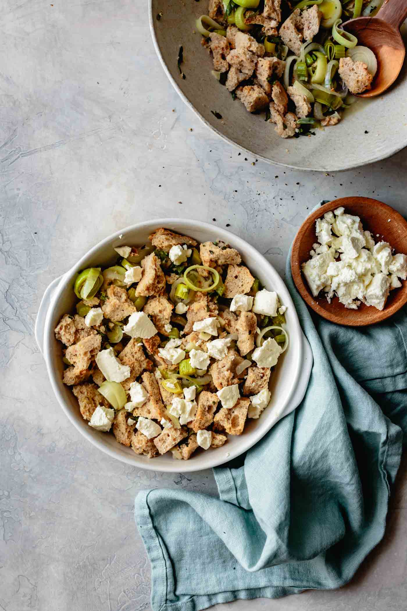 Layering gluten-free stuffing ingredients in a pan with goat cheese