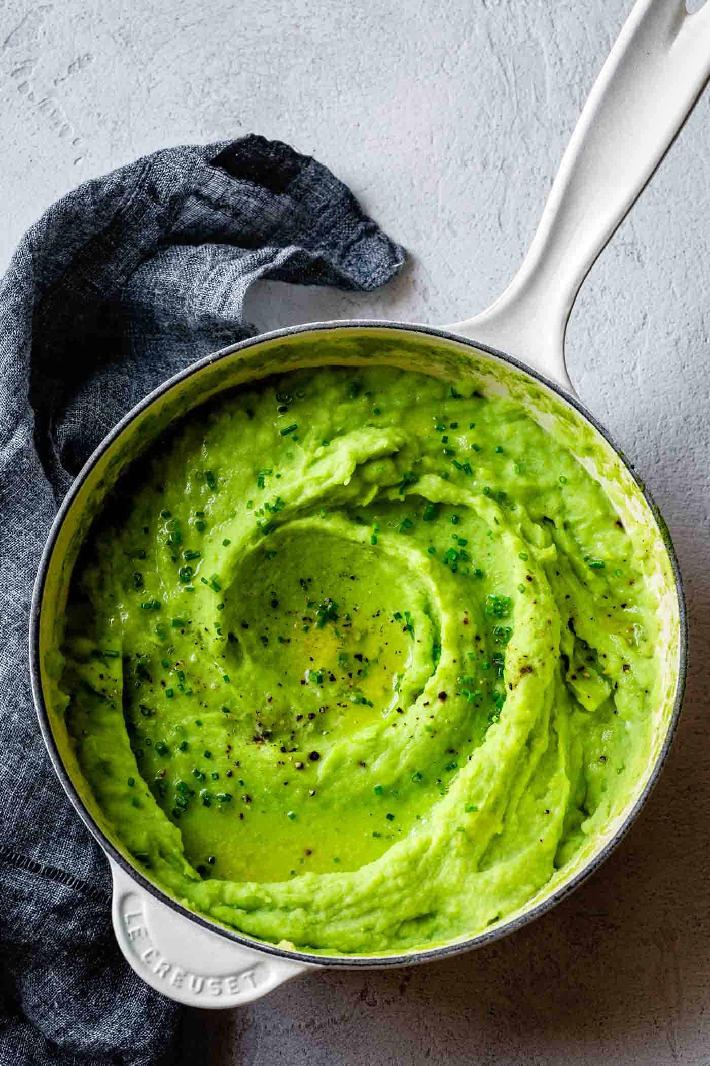 Green Goddess Mashed Potatoes in a pot with a swirl of butter