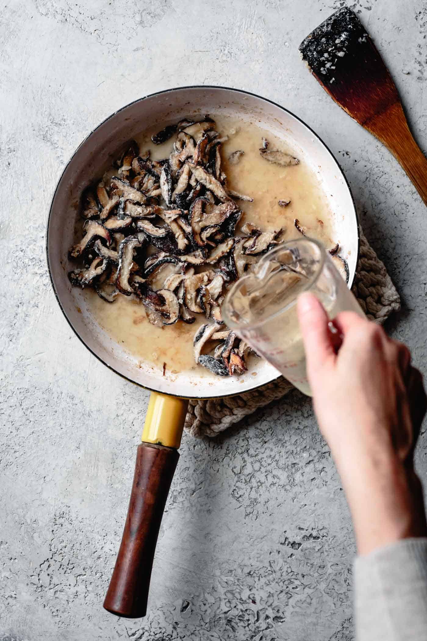How to make mushroom gravy: adding vegetable stock to the mushrooms in the pan
