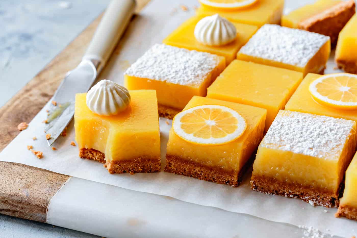 lemon bars on a marble wood board with a bite taken out