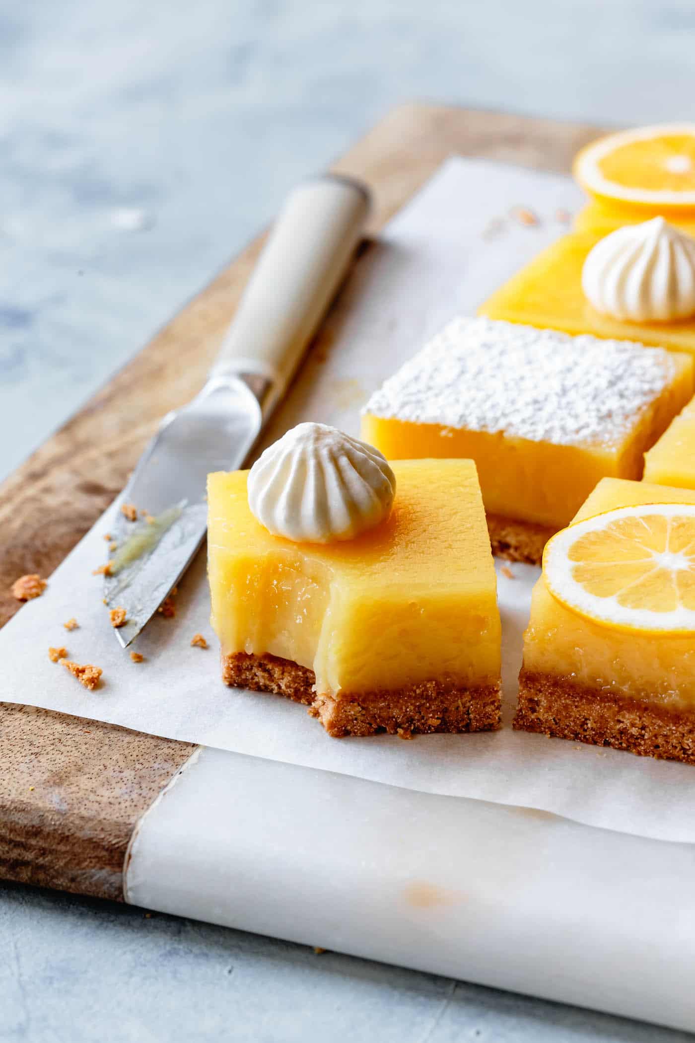 a lemon bar on a cutting board has a bite taken out