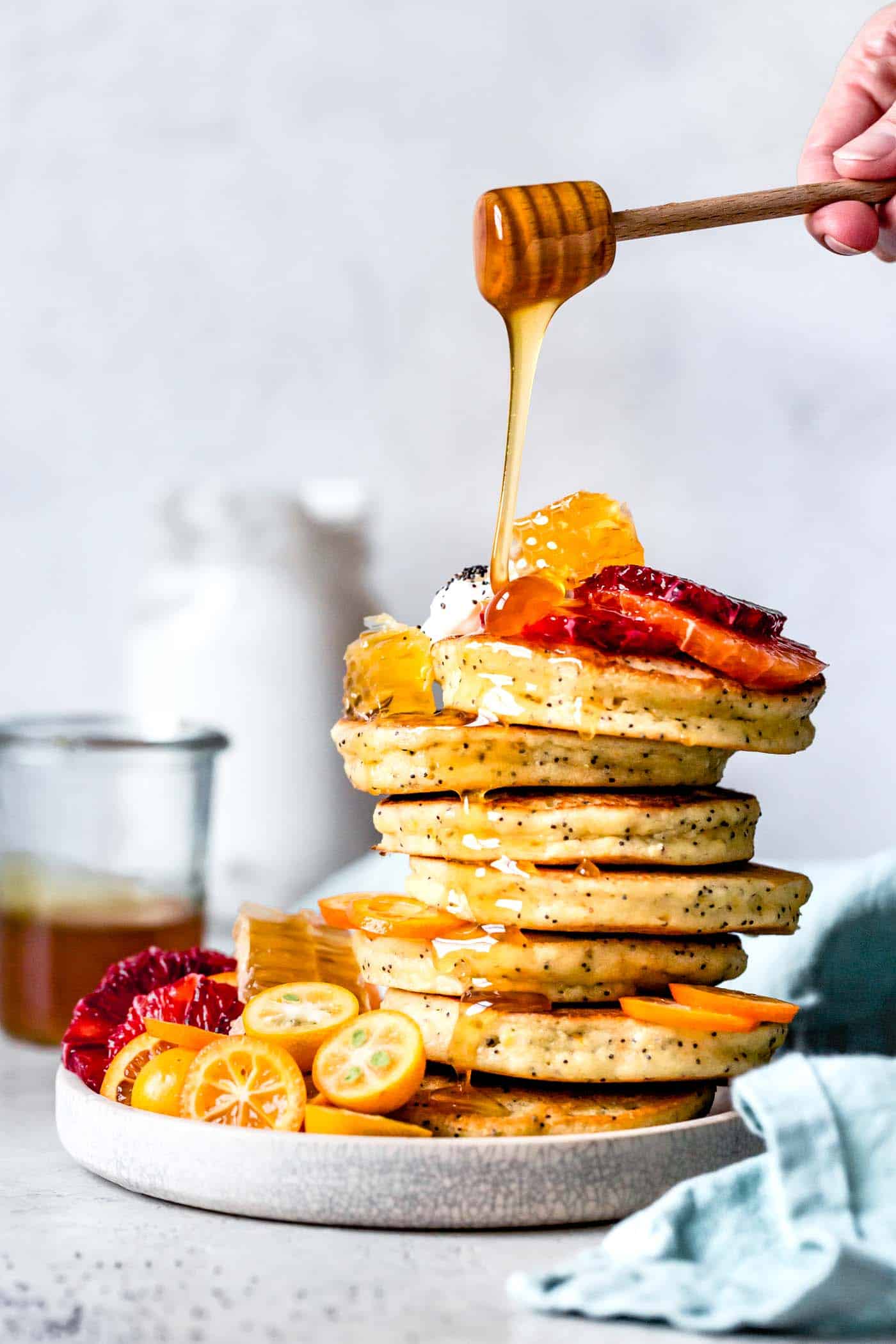 drizzling honey on citrus poppy seed almond flour pancakes