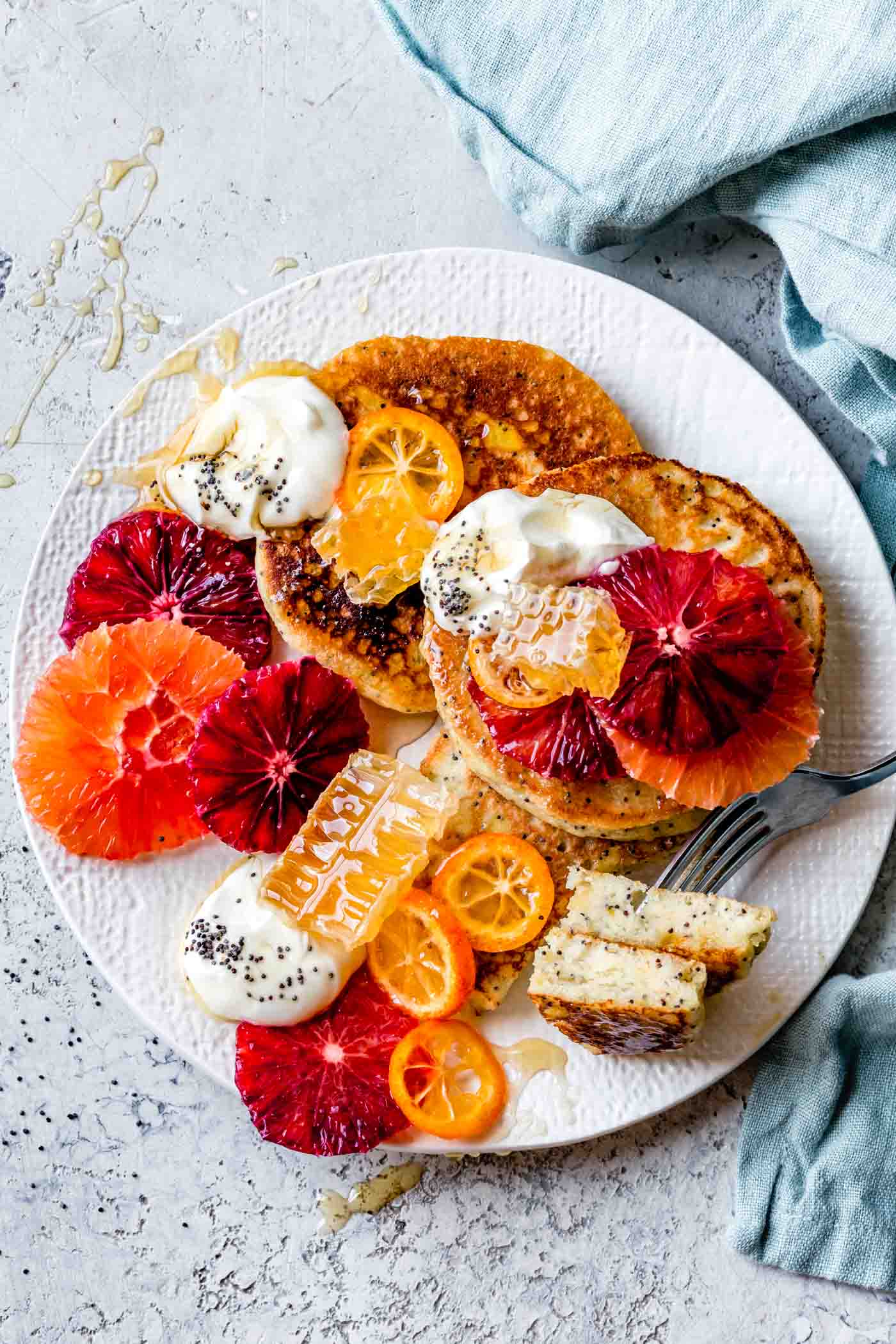 A plate of fluffy almond flour pancakes with citrus and poppy seeds