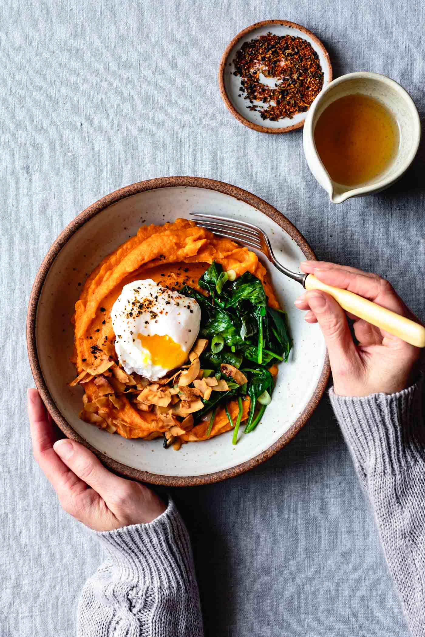 Hands are diving into a cozy breakfast bowl