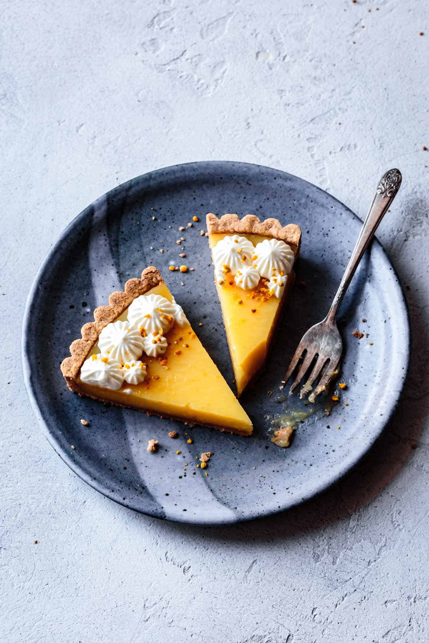 Slices of lemon curd tart recipe on a plate, overhead