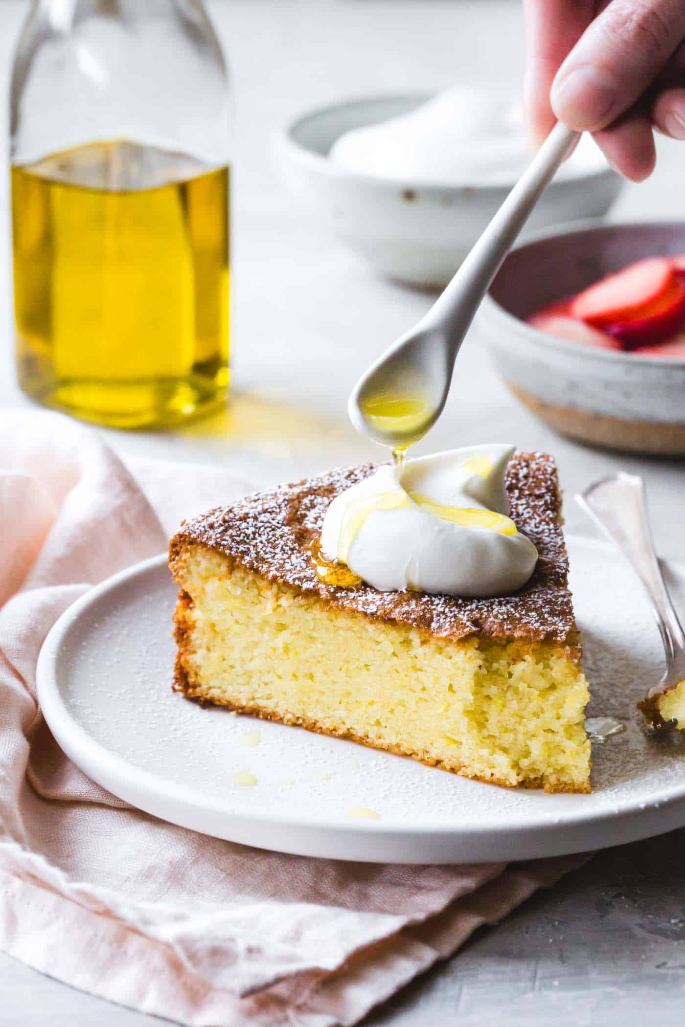 olive oil is being drizzled onto a slice of almond flour cake