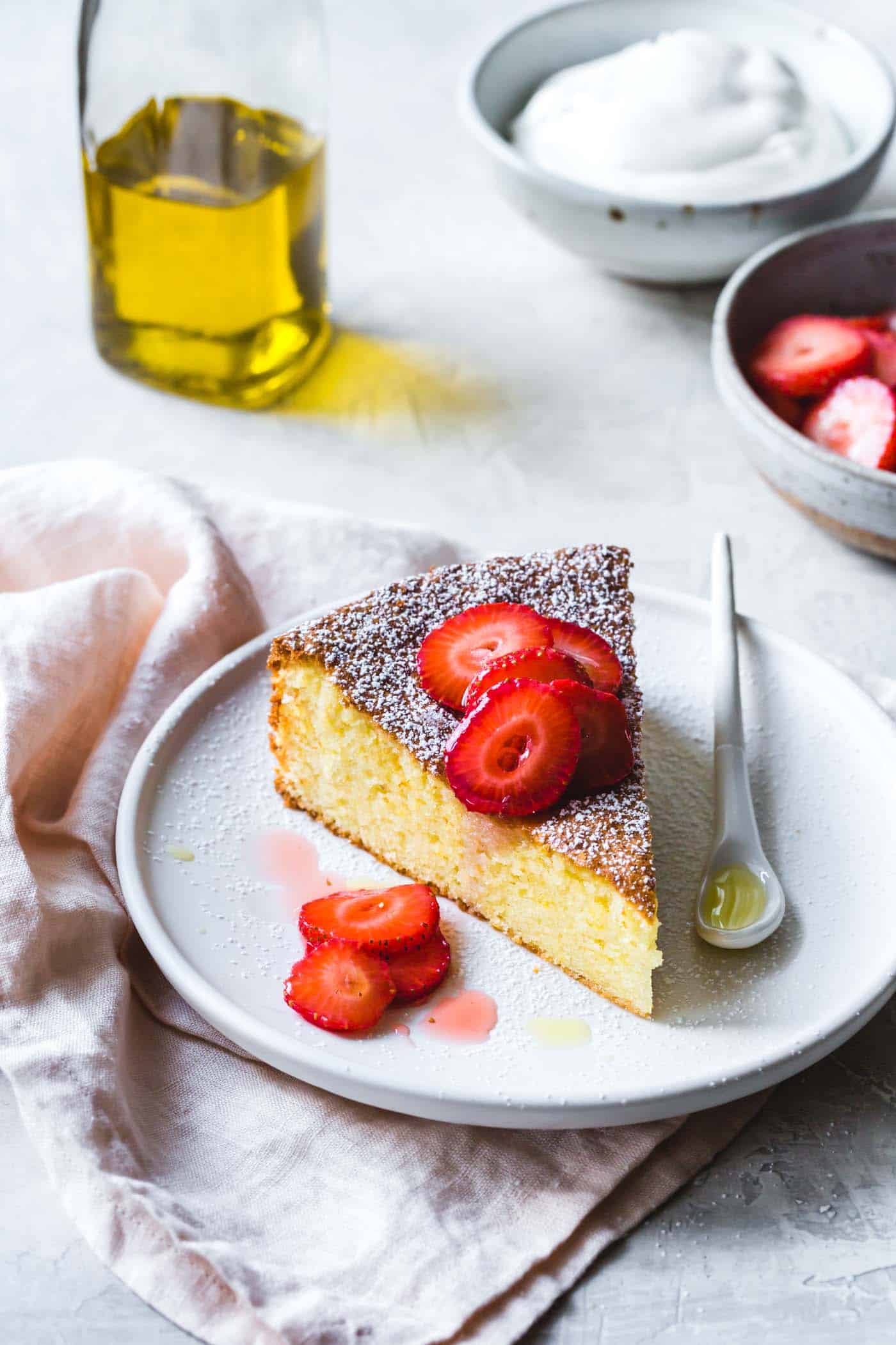 Gluten-free almond cake with lemon and olive oil, on a plate with strawberries