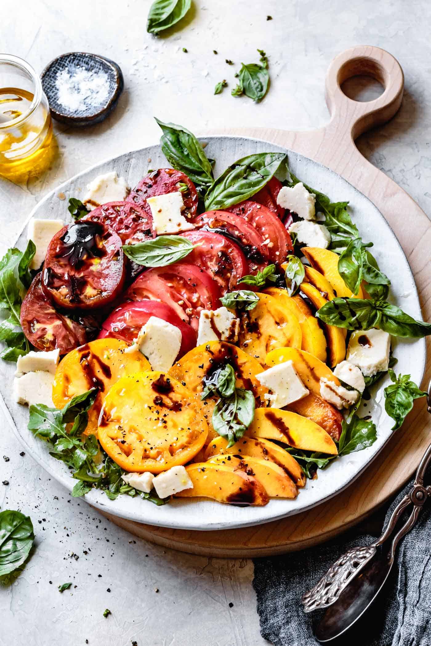 Alternate view of vegan peach caprese salad with arugula on a platter