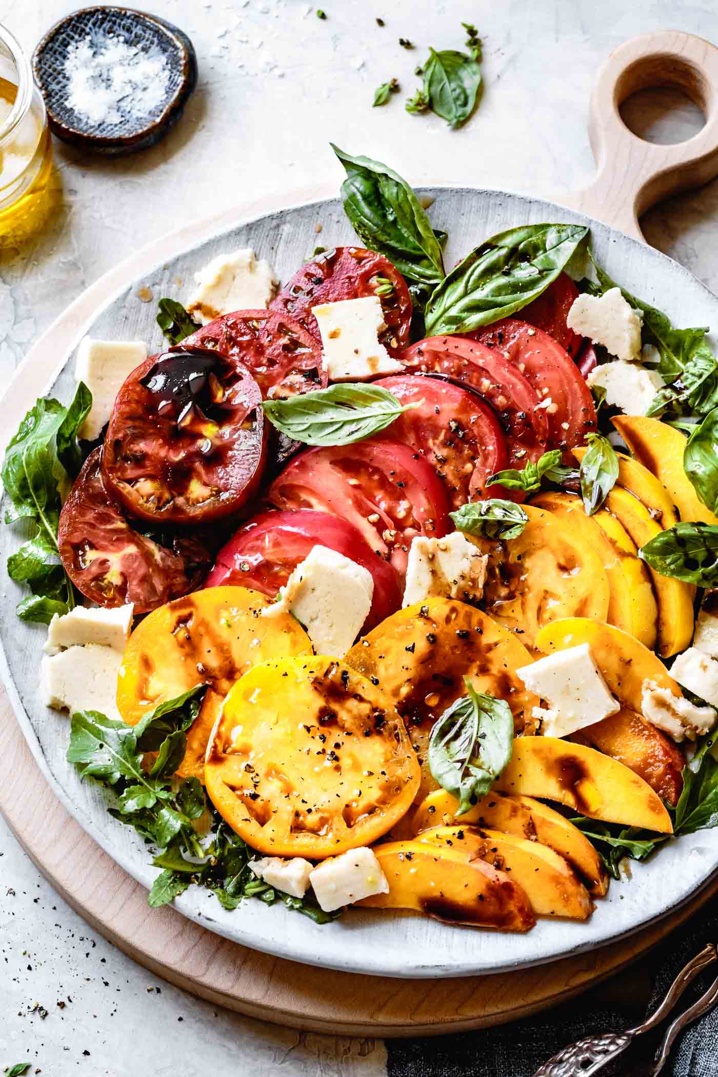 Vegan Caprese Salad with Peaches and Arugula on a platter