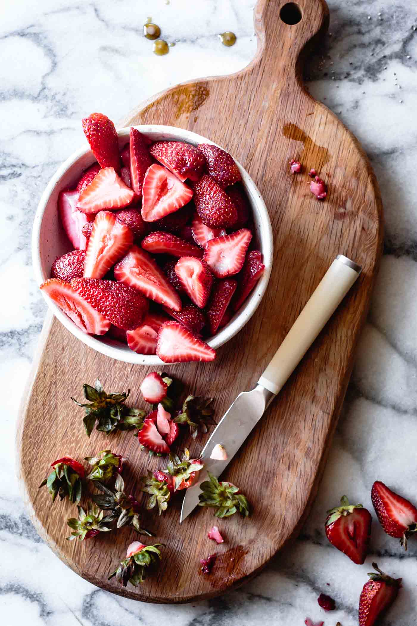 hulling and slicing strawberries for simple strawberry rhubarb jam recipe