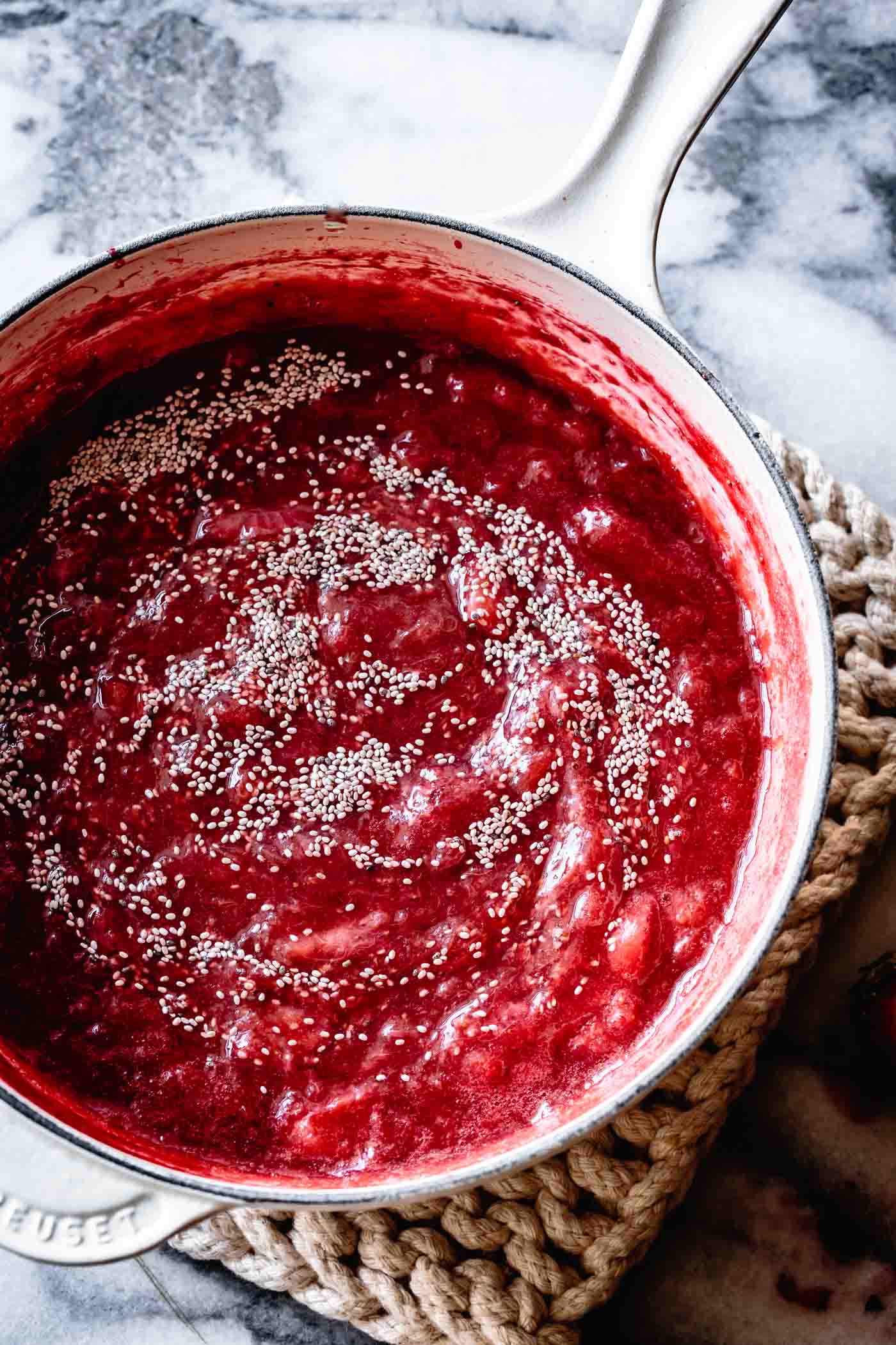 adding chia seed to strawberry rhubarb chia jam