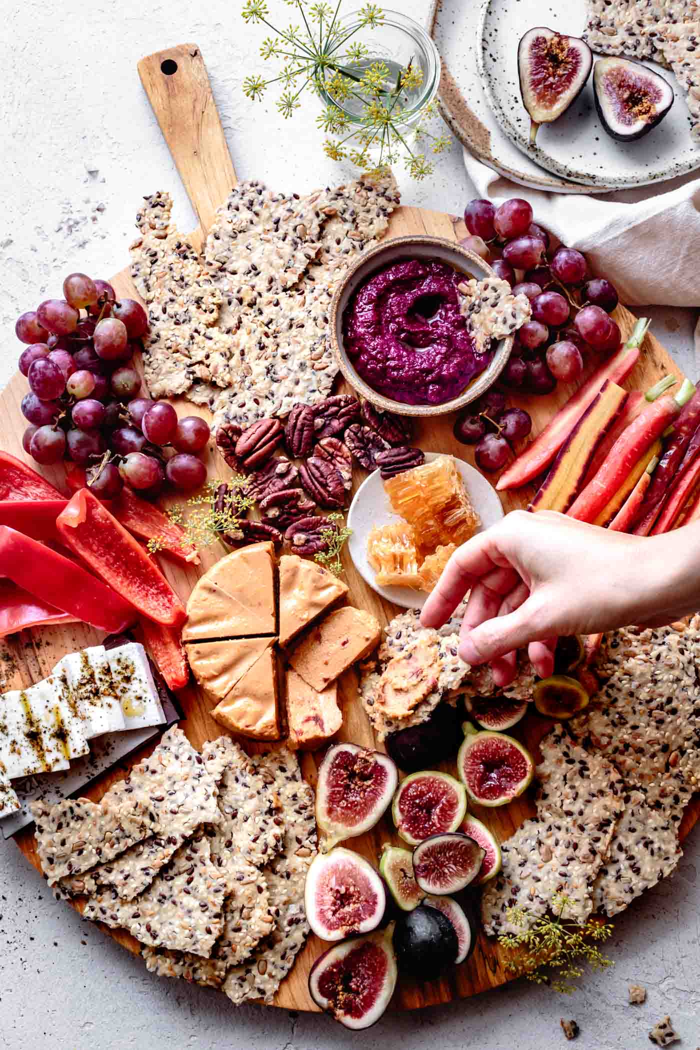 spreading a paleo cracker with cheese