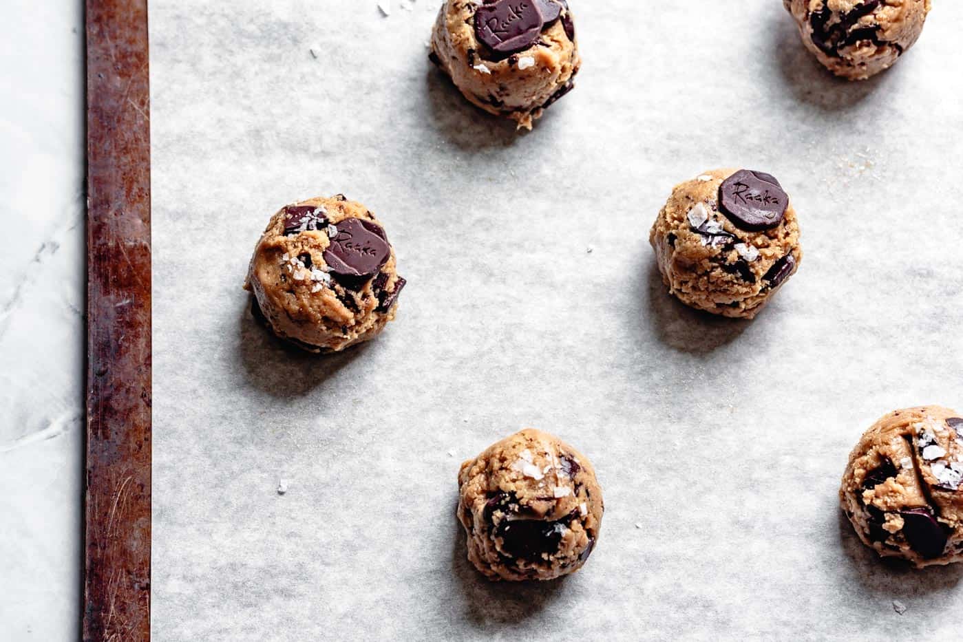 scooped tahini cookie dough balls on a baking sheet