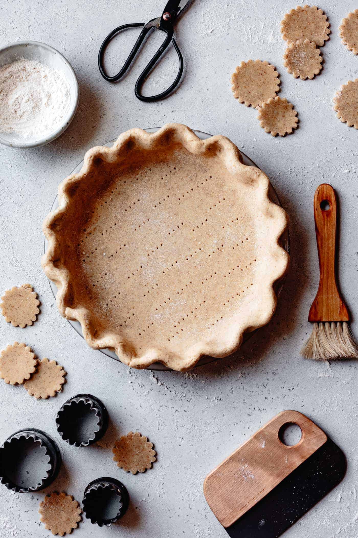 an unbaked pie crust made with almond and cassava flours sits on a flour-topped work surface 