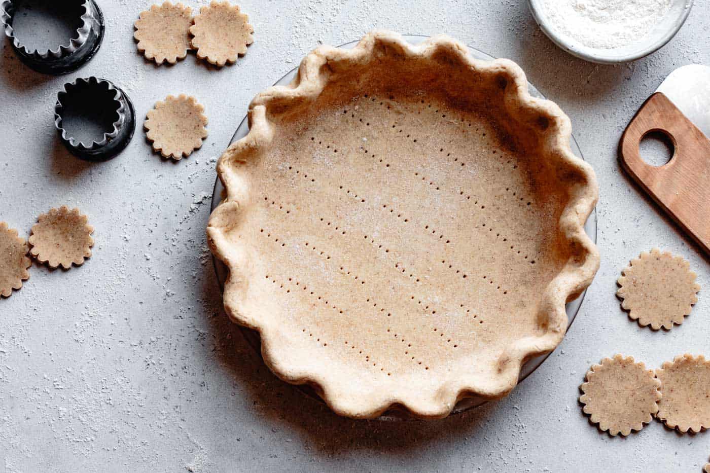 an unbaked paleo pie crust is on a counter surface ready to bake