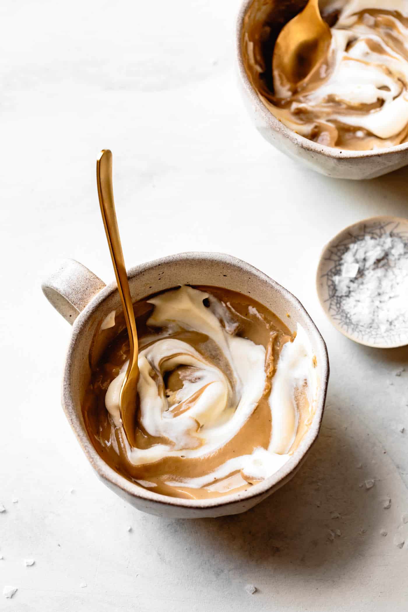 vegan butterscotch pudding with whipped cream swirled in a mug