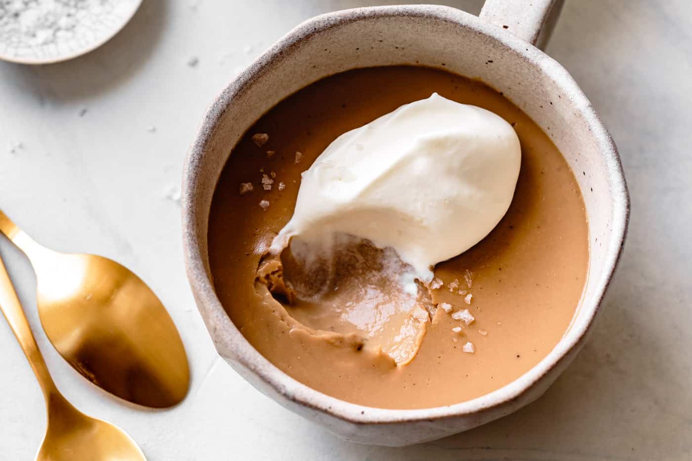 butterscotch pudding dessert in two mugs with spoons