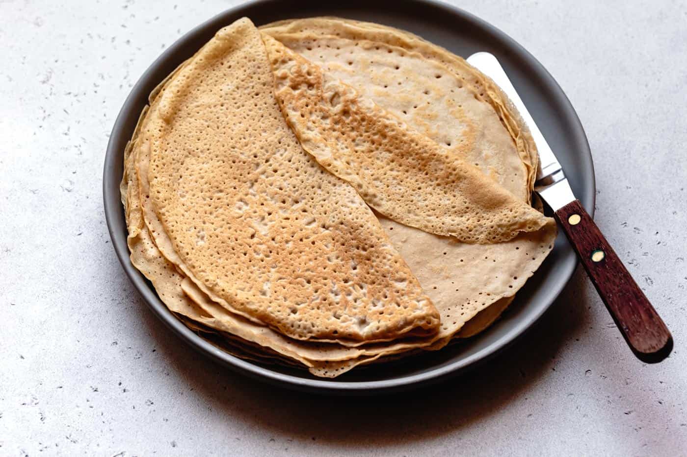 dairy-free almond milk crepes stacked on a plate