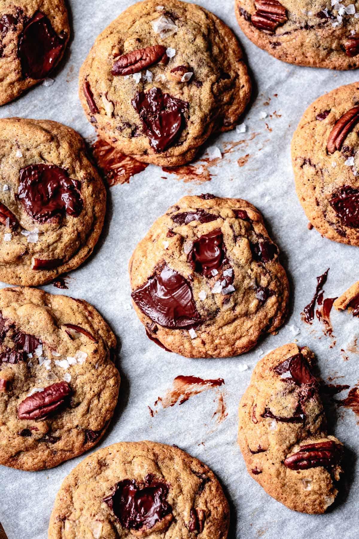 gluten free chocolate chip cookies made with oat flour are on a messy piece of parchment paper