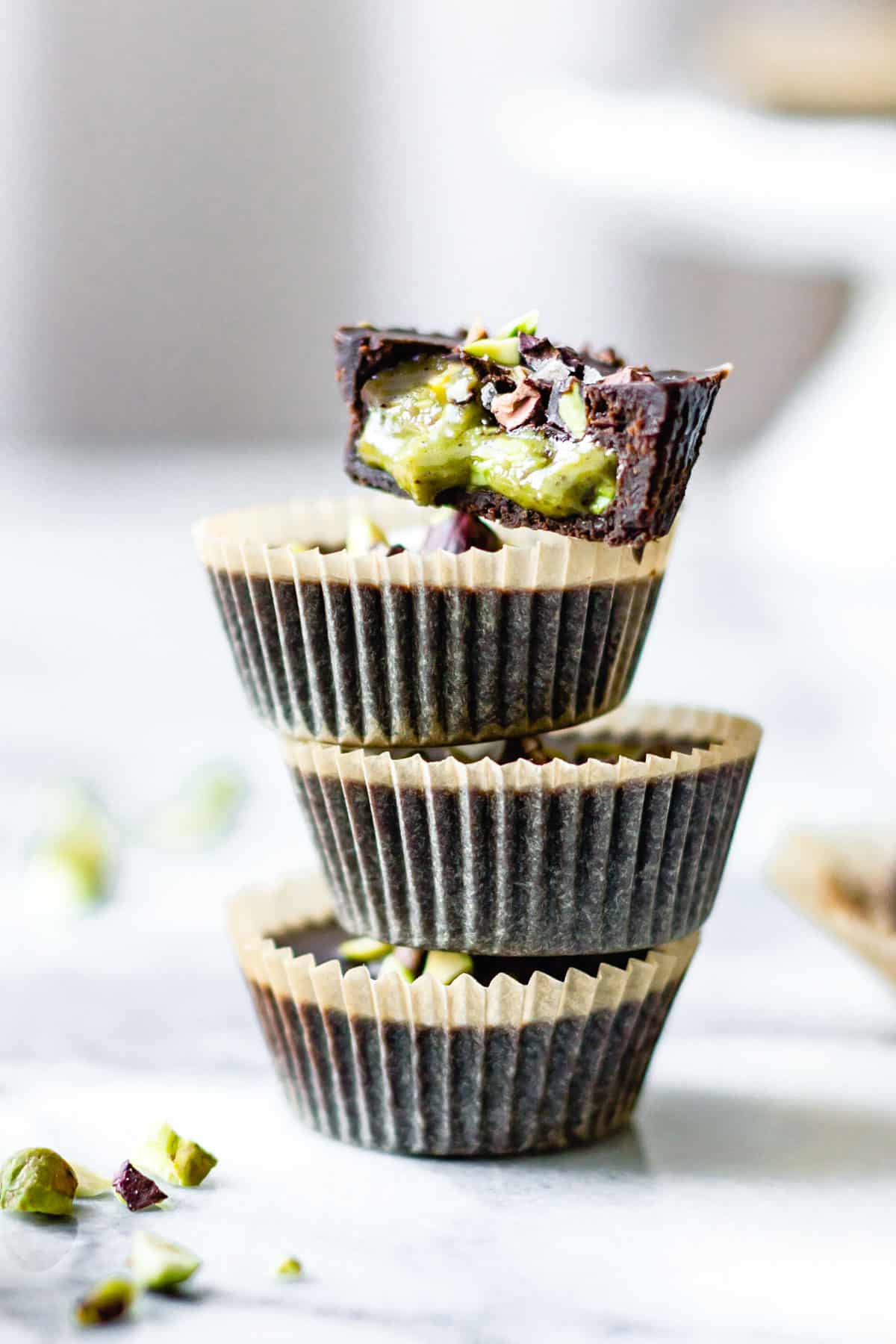 stack of chocolate pistachio butter cups against white background