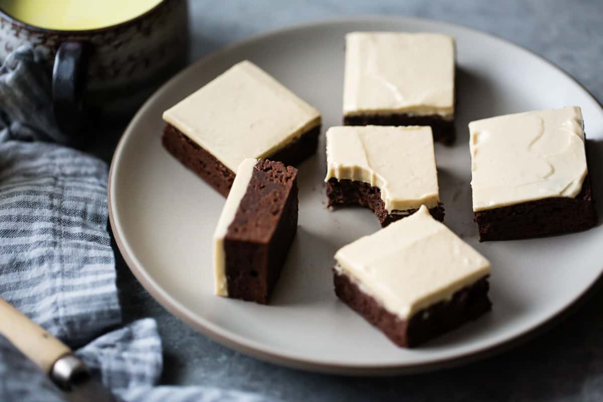 frosted brownies on a beige plate