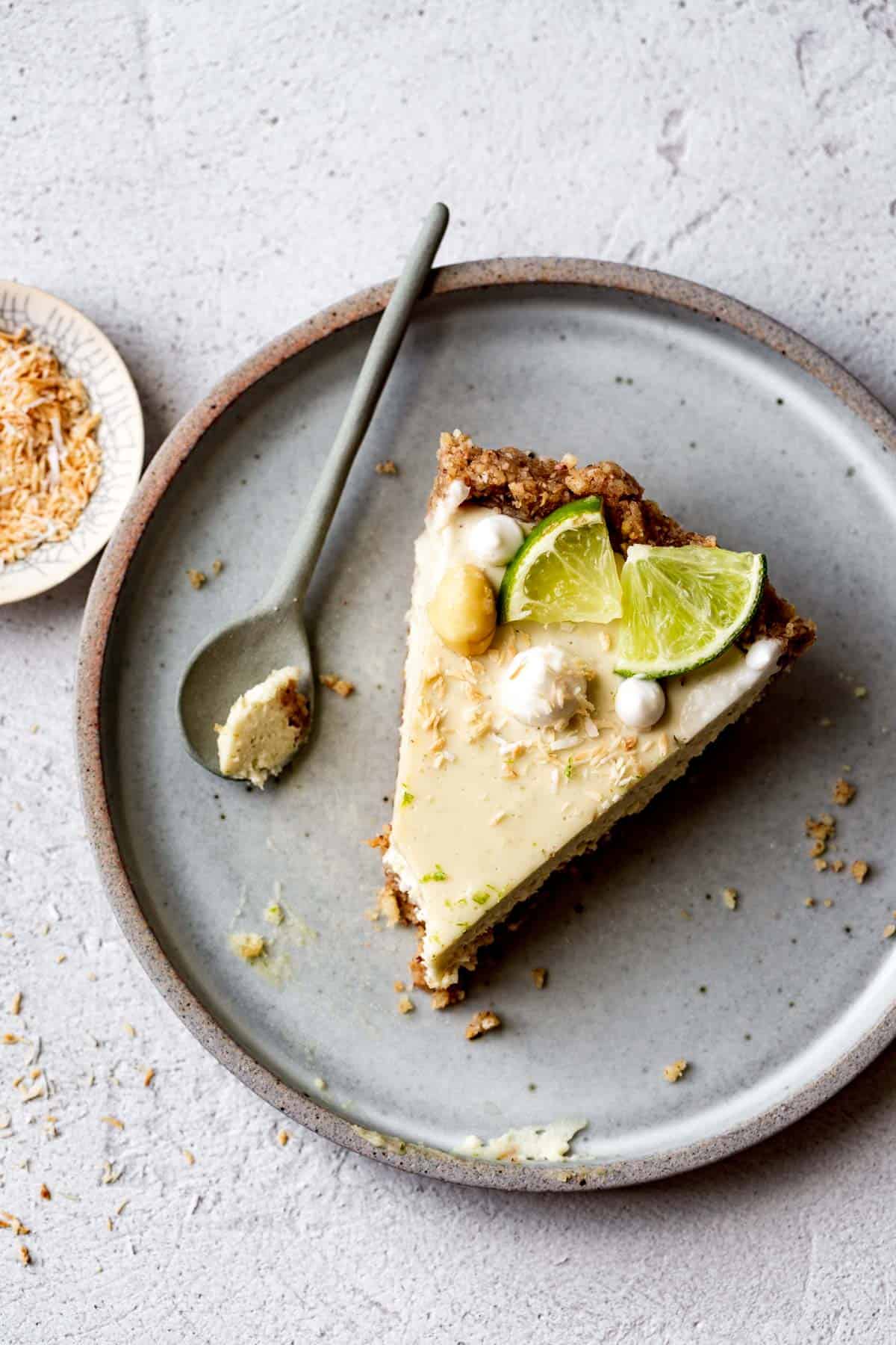 slice of raw key lime pie on a plate with a bite taken out