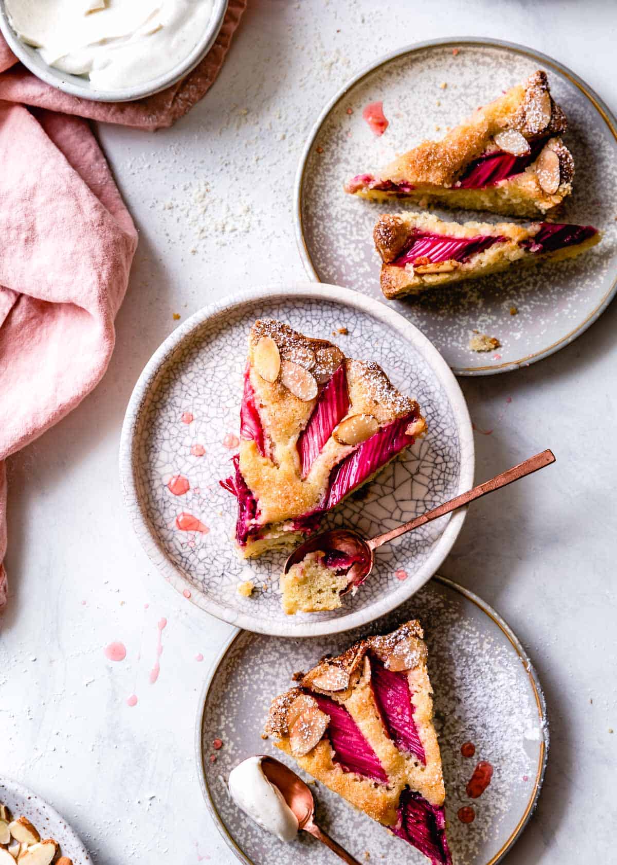 three plates with slices of gluten-free rhubarb cake, overhead