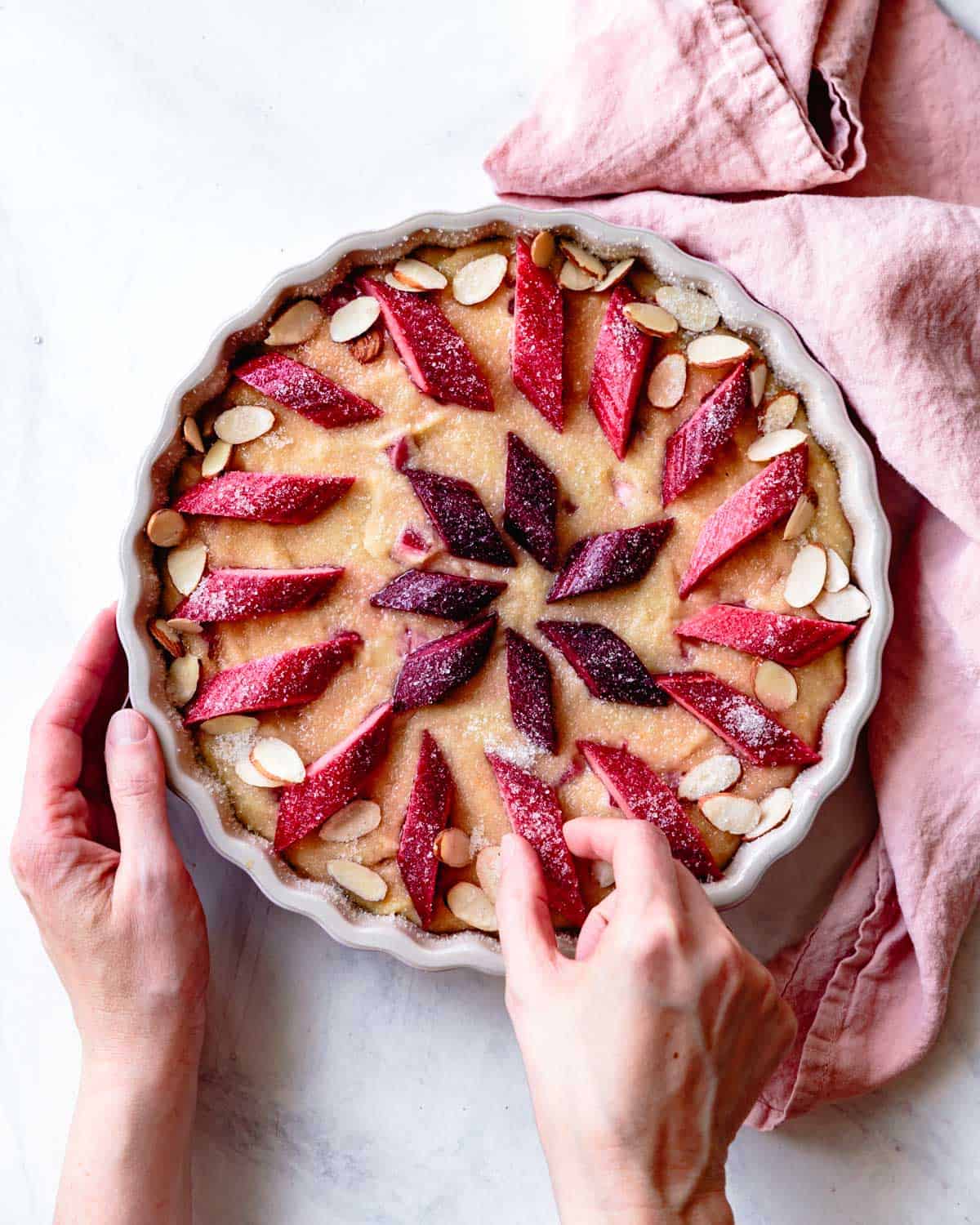 placing rhubarb slices and almonds over the cake