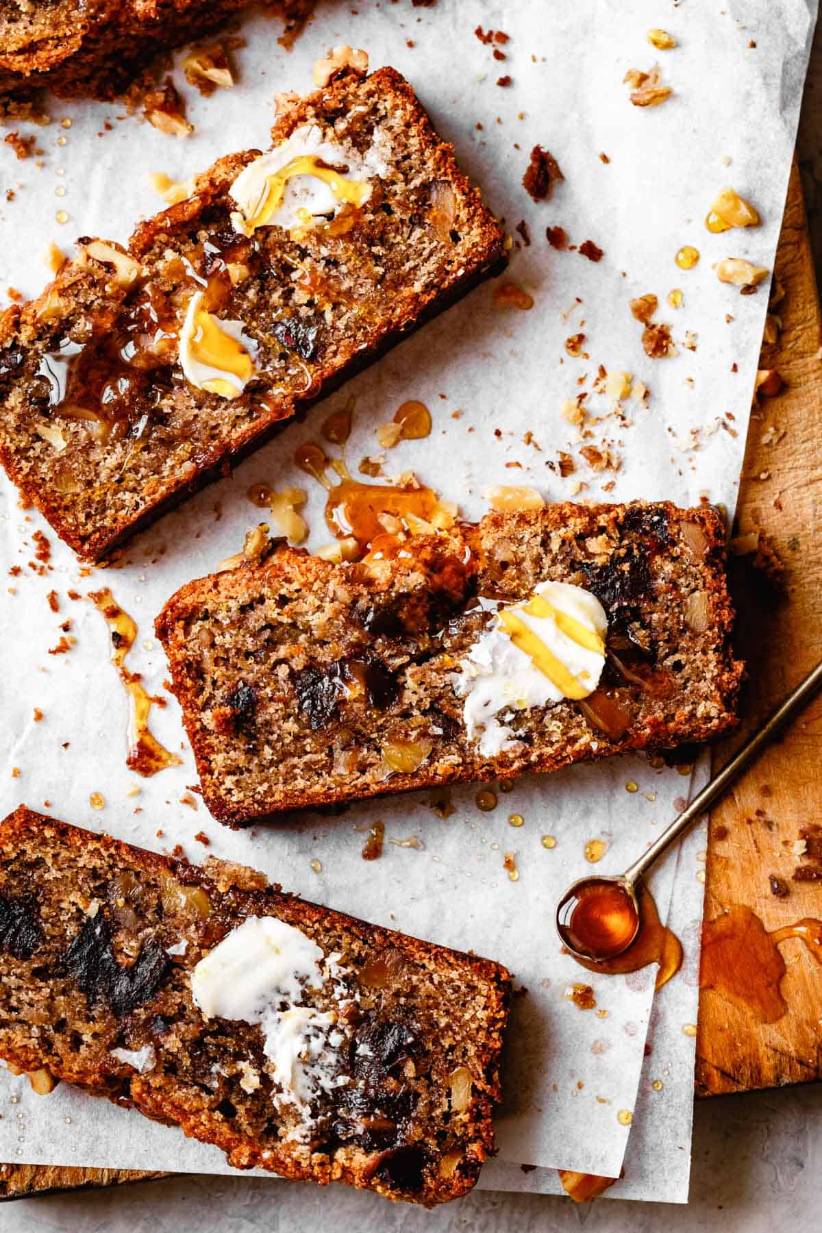 slices of banana bread on parchment with honey drizzle