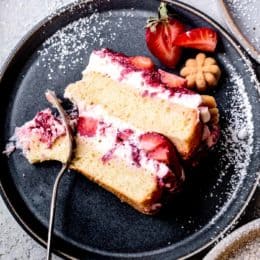 close-up of slice of gluten-free strawberry cake on a plate with powdered sugar