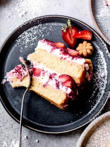 close-up of slice of gluten-free strawberry cake on a plate with powdered sugar