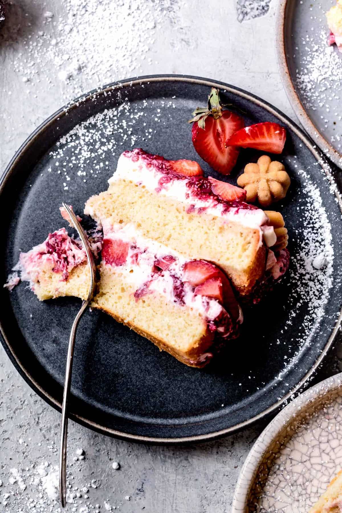 close-up of slice of gluten-free strawberry cake on a plate with powdered sugar