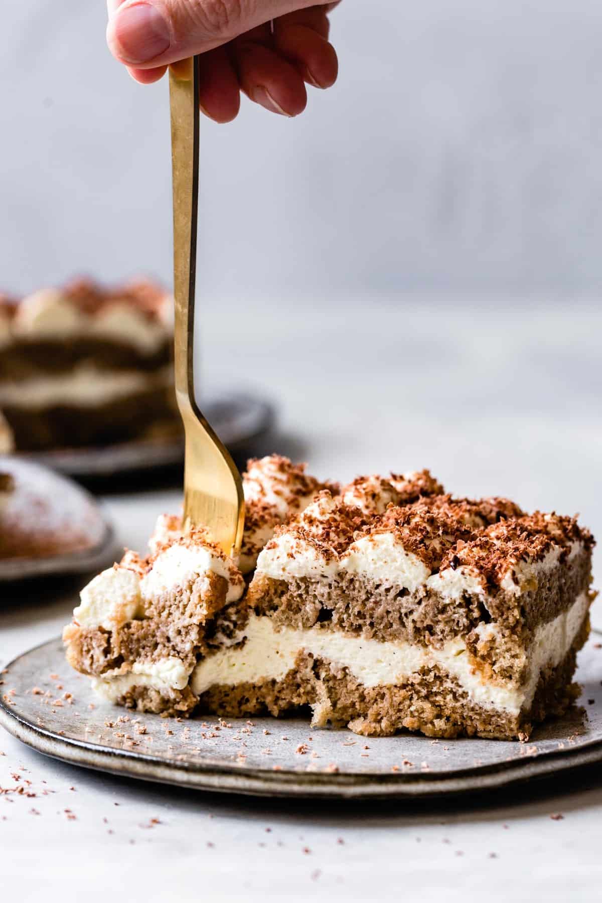side view of layered GF tiramisu with a fork diving in