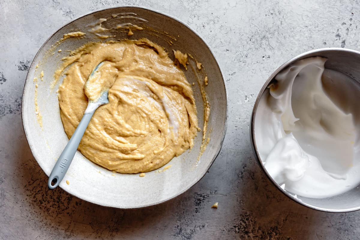 one-third of the beaten egg whites are being folded into the batter