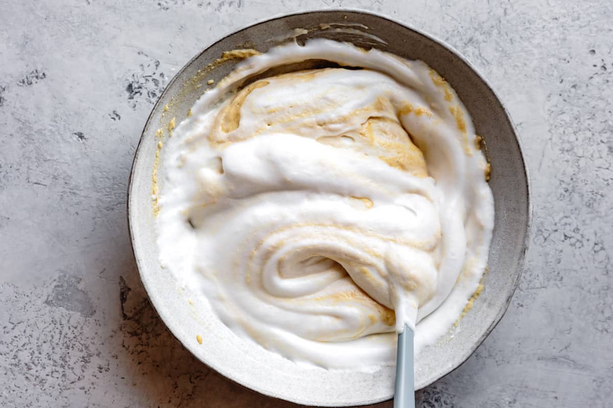 the batter is mostly stirred together with swirls of beaten egg white and golden batter 