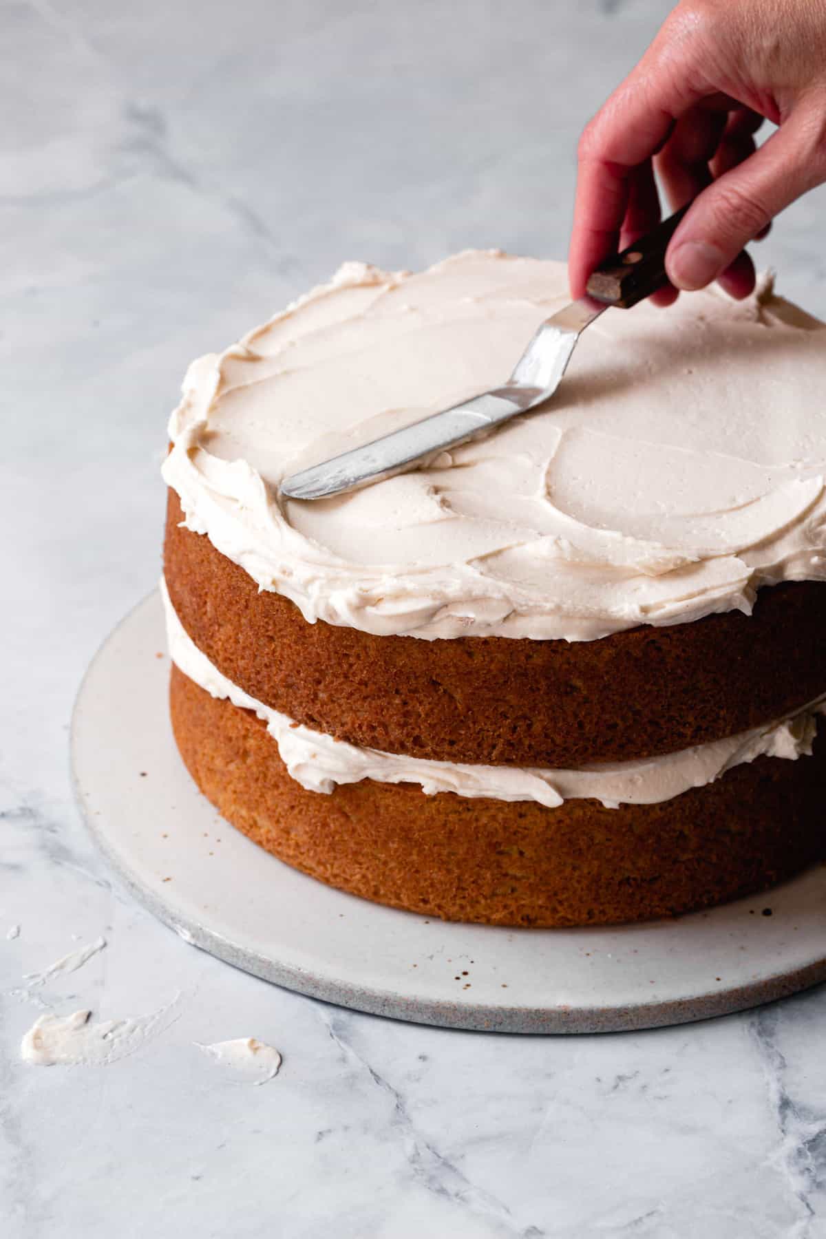 paleo icing being spread on a layer cake