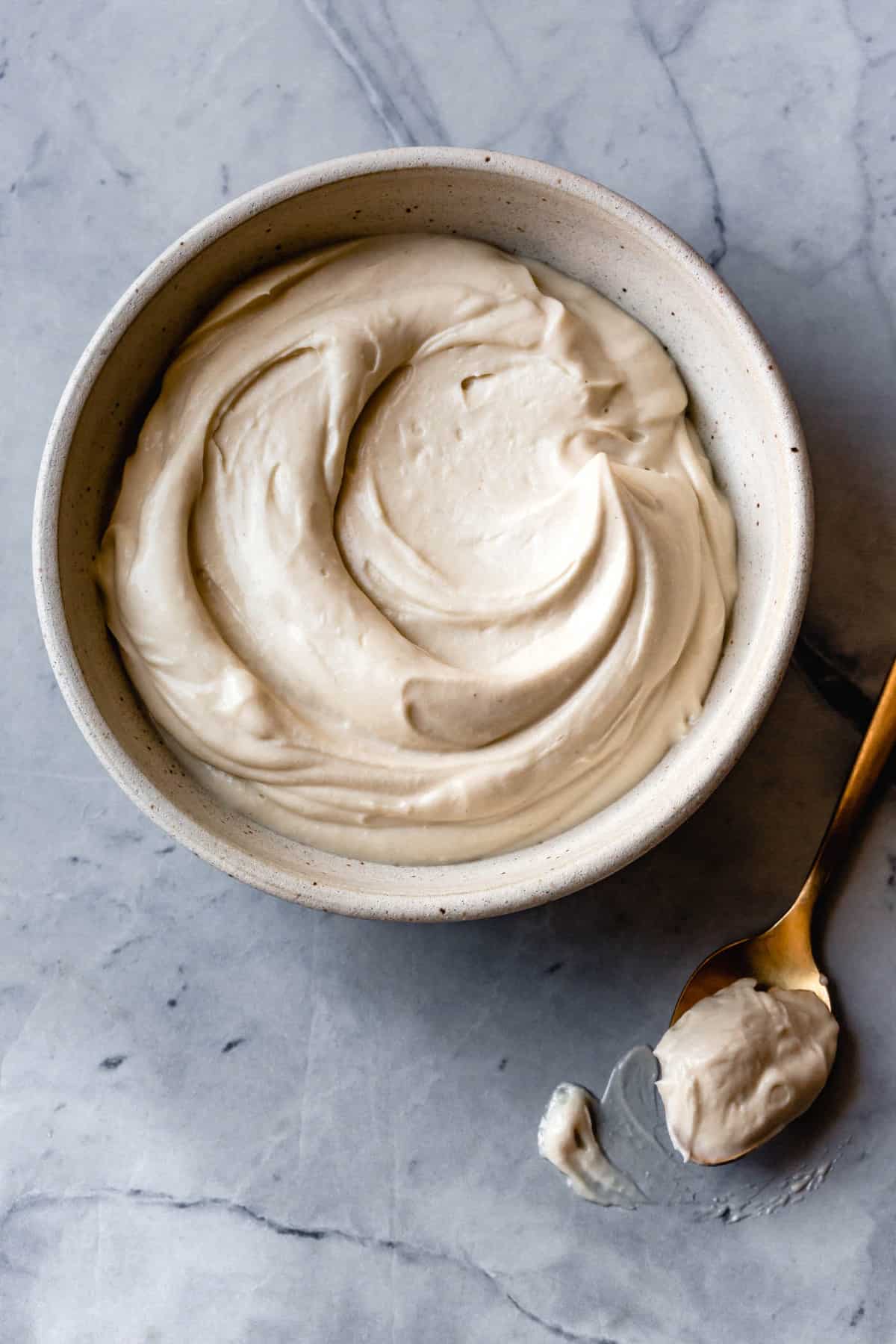 paleo cream cheese frosting swirled in a white bowl