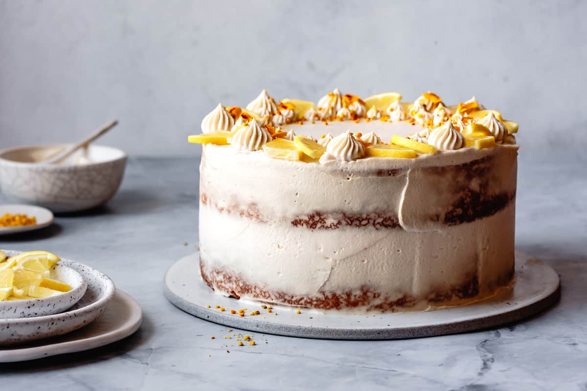 frosted cake with partially naked sides, side view