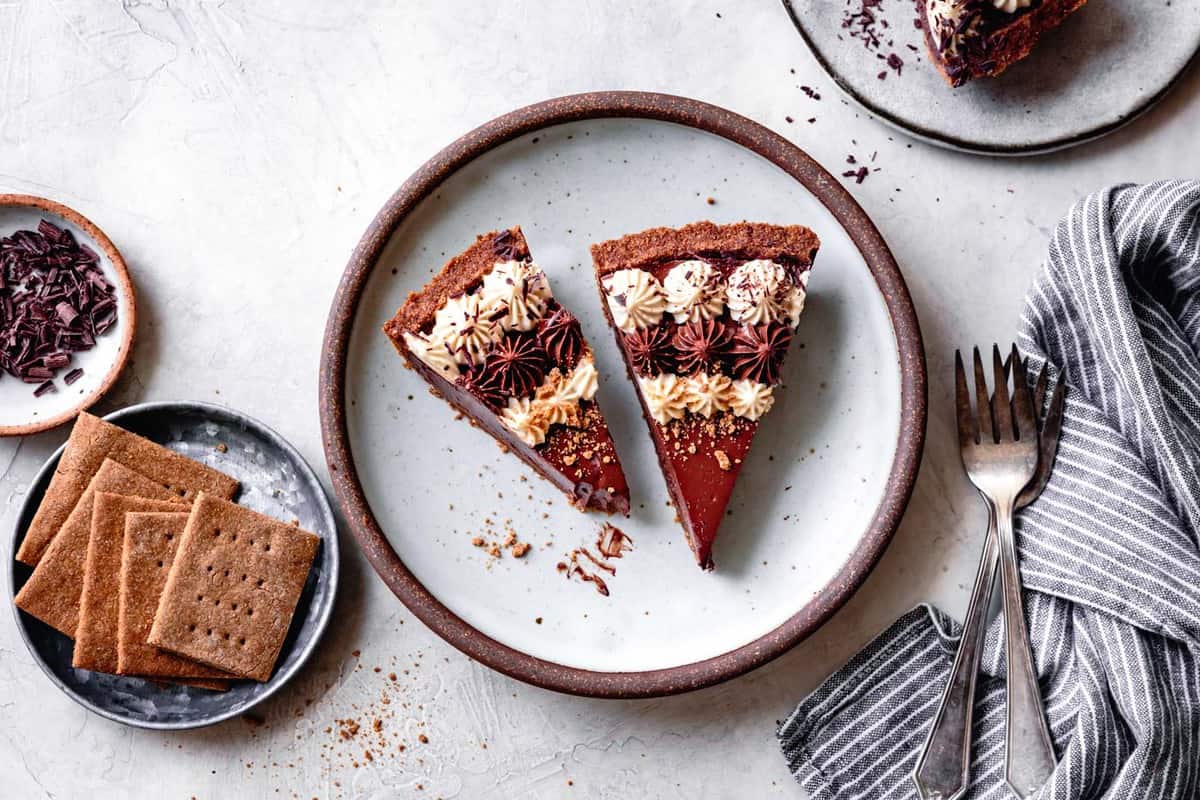 two slices of gf chocolate cream pie on a light blue plate with graham crackers