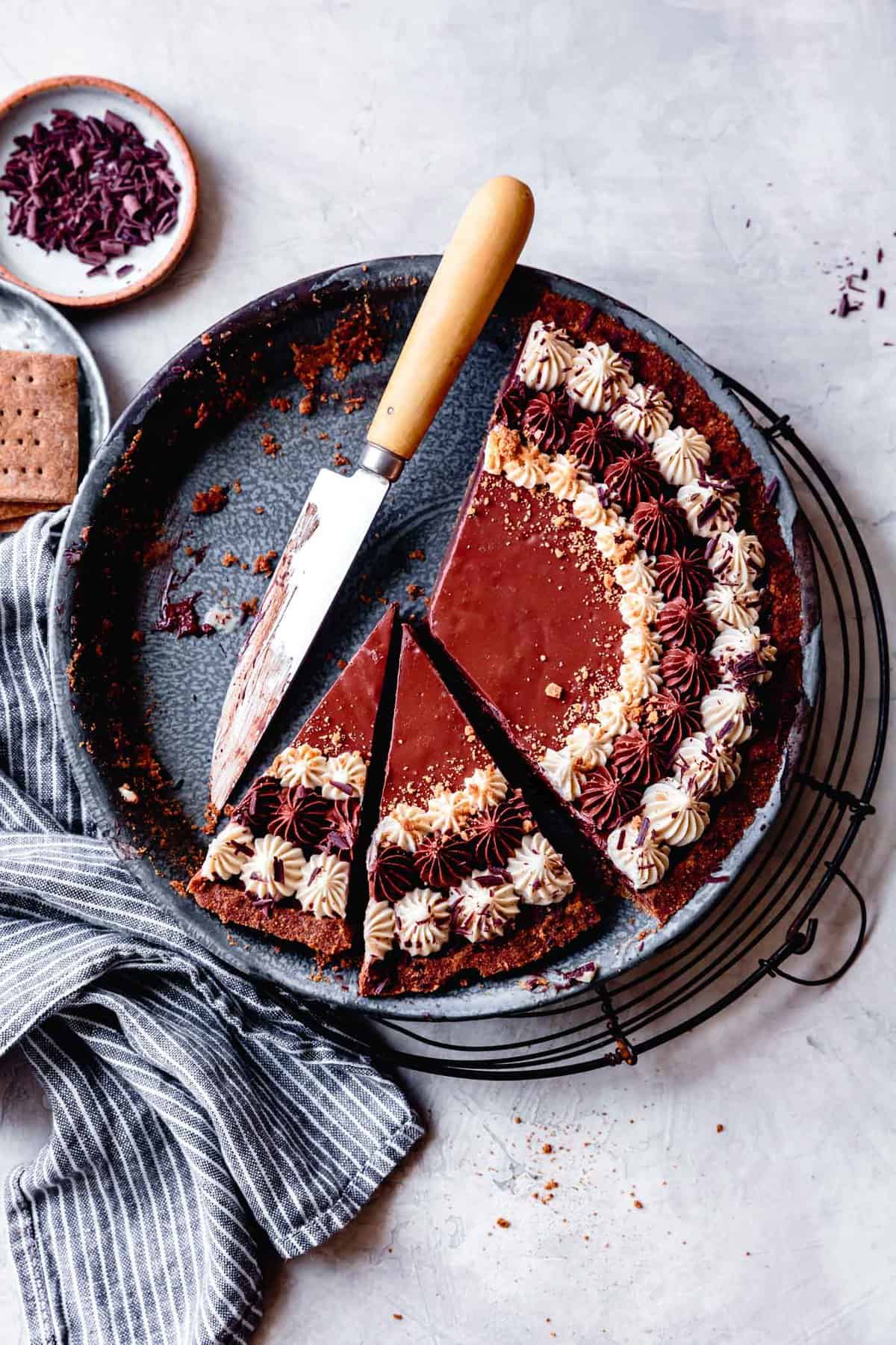 healthy chocolate pie, partially sliced in a blue graniteware pit tin with a knife