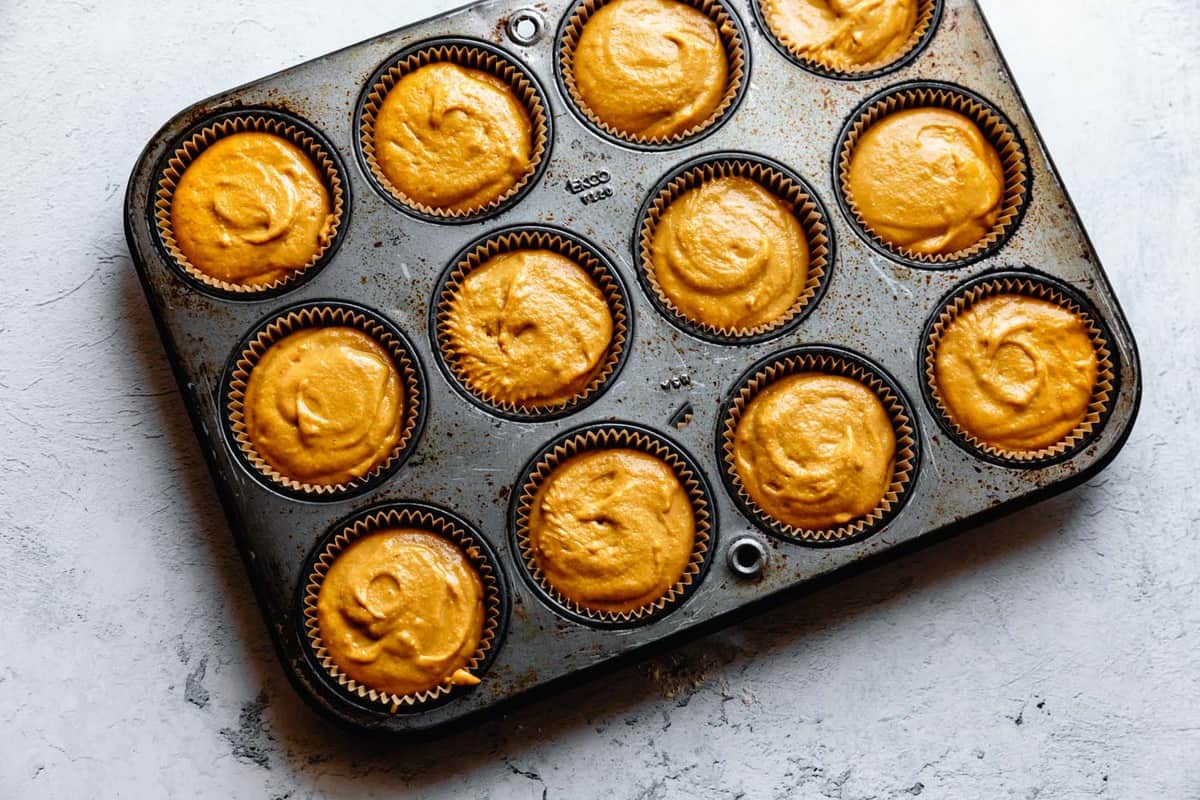 muffin batter scooped into tins