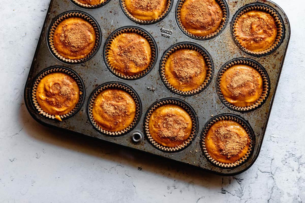 unbaked muffins sprinkled with cinnamon sugar