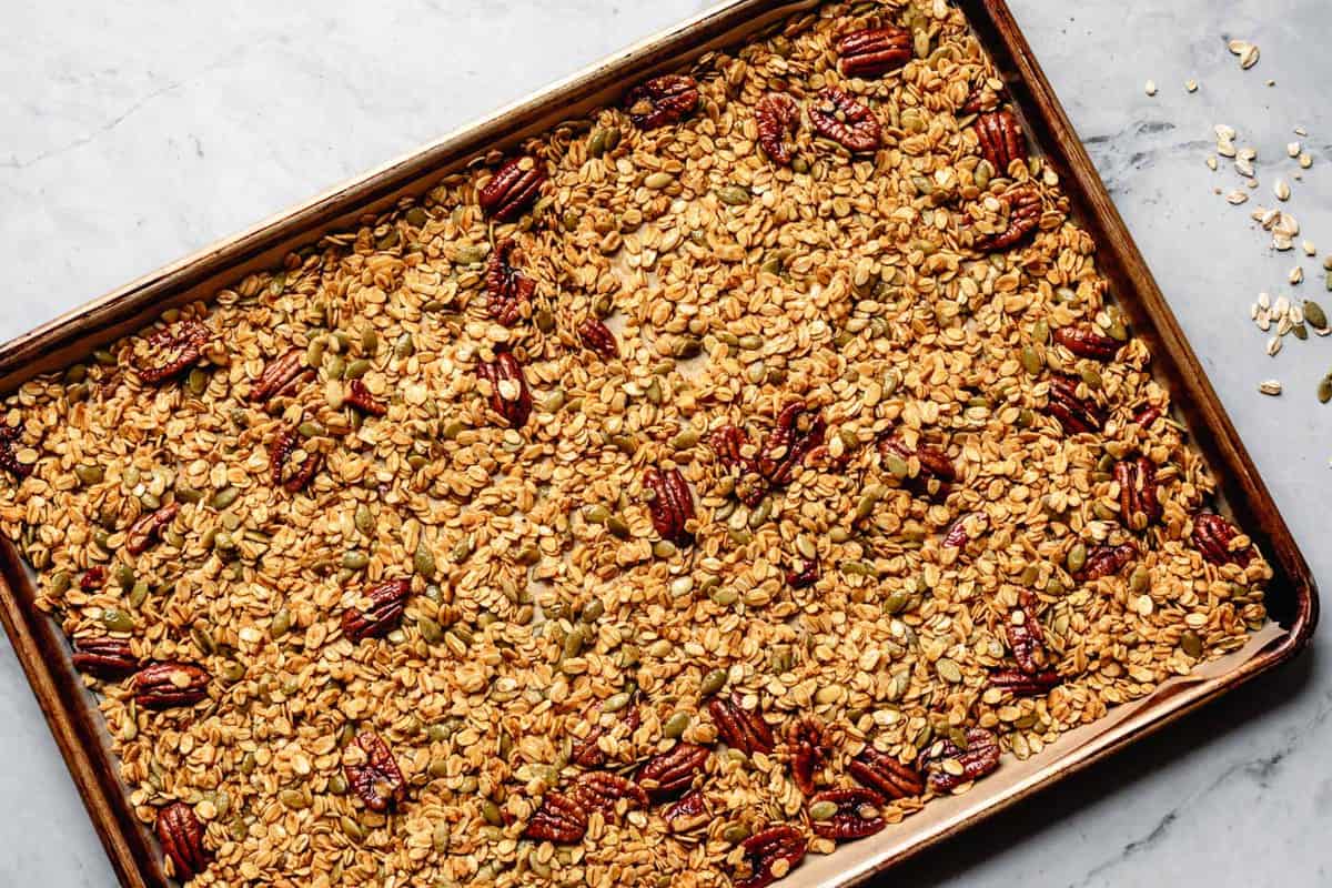 unbaked granola spread evenly on a sheet pan